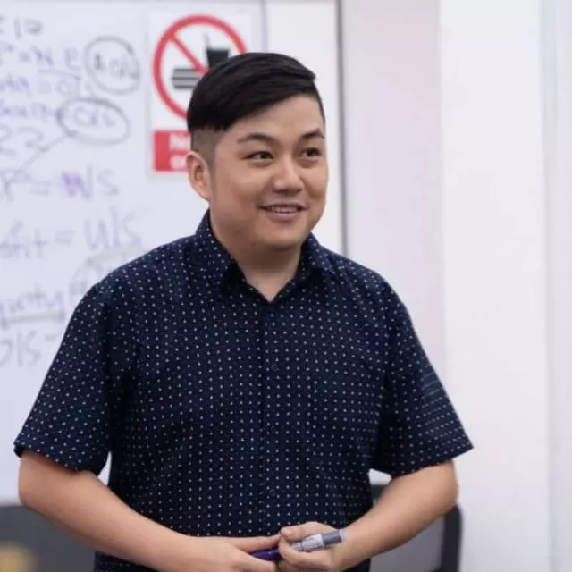 Caleb Ho teaching Principles of Accounts in a classroom